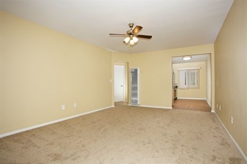 A room with a ceiling fan and carpeted floor.