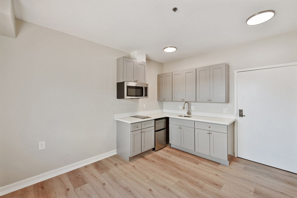 a kitchen with white cabinets and a wooden floor at Azure Point at Encinitas, California, 92024