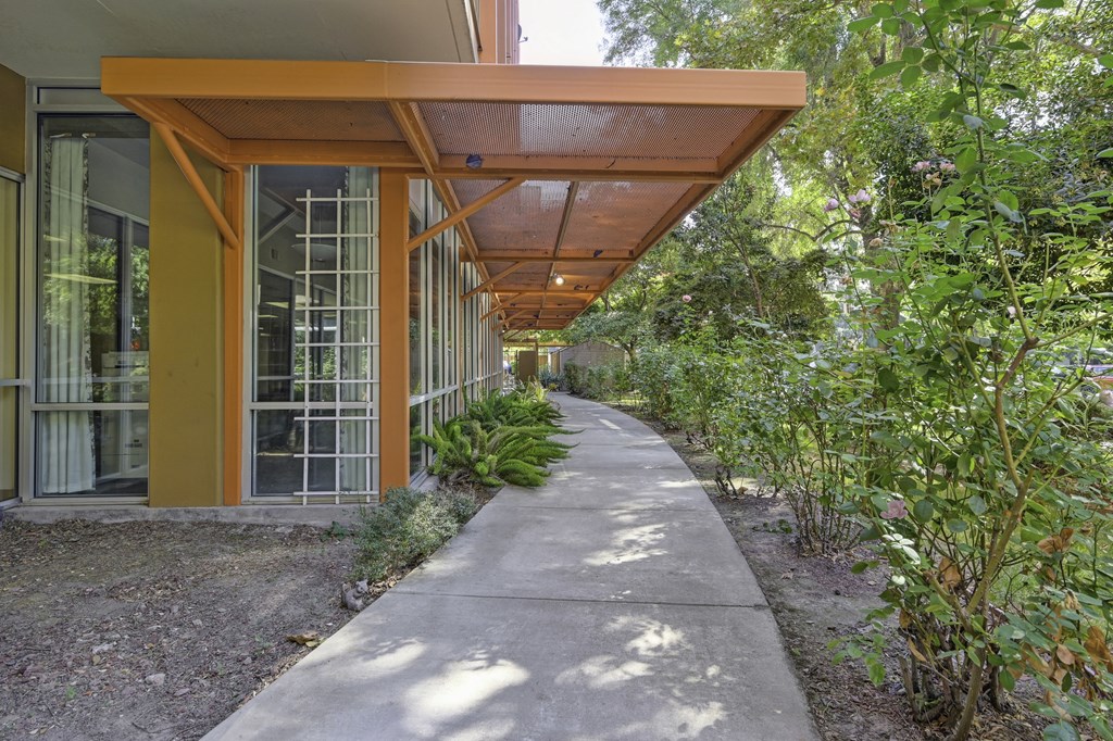 the walkway to the house is lined with plants and trees at The Riverview (55+), Sacramento, CA 95814