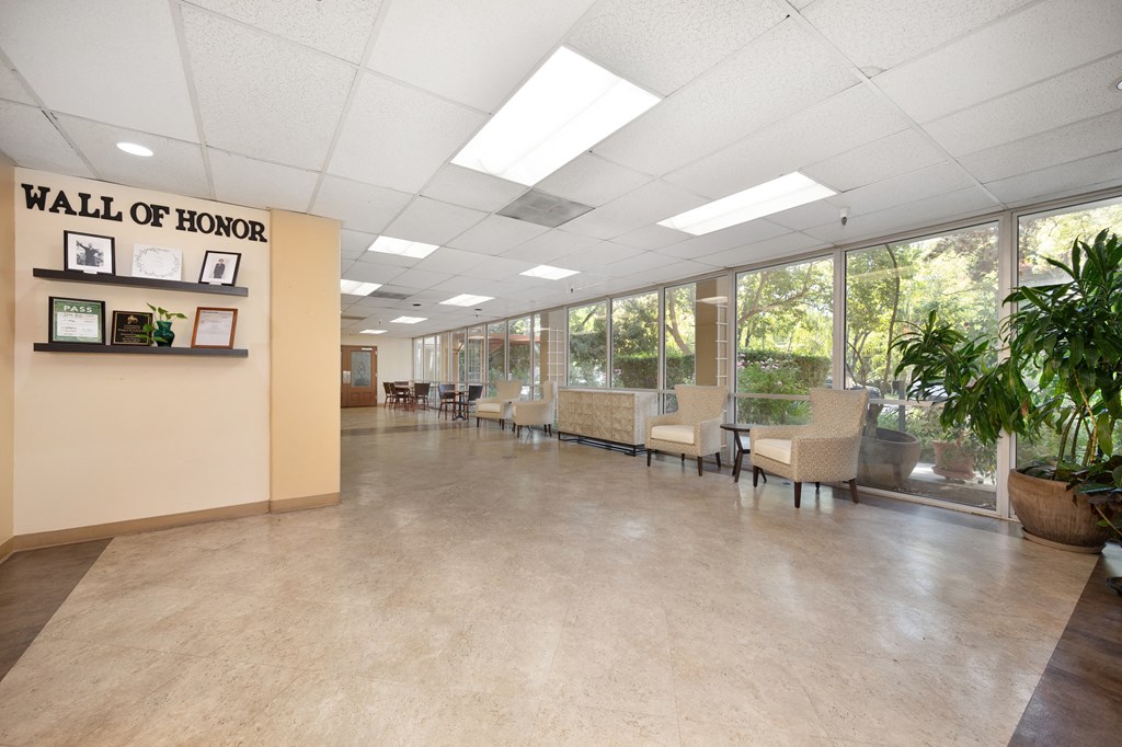 a hallway with chairs and tables and a wall of honor at The Riverview (55+), Sacramento