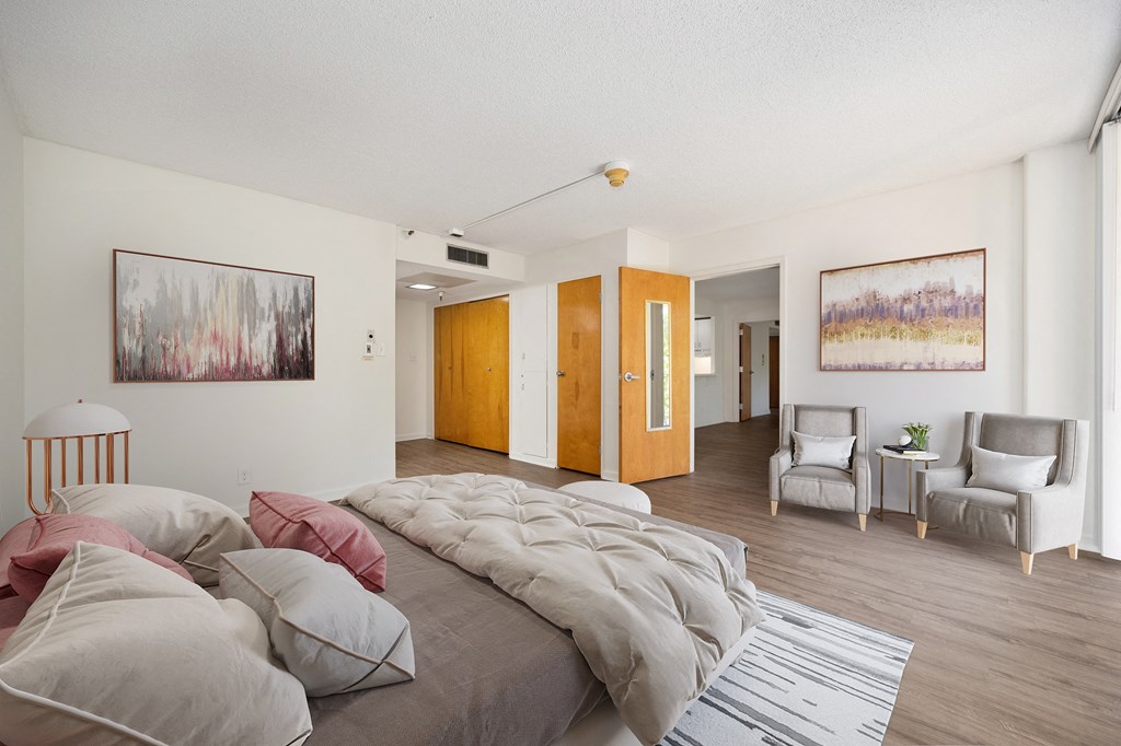 a bedroom with a bed and a living room at The Riverview (55+), Sacramento, CA 95814