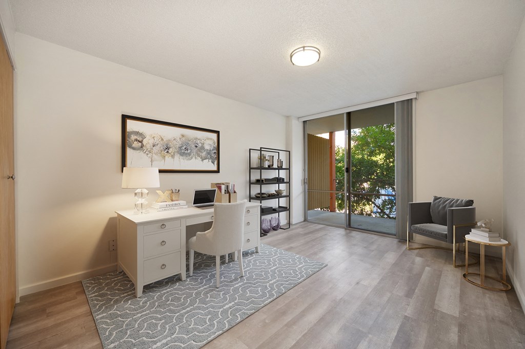 a home office with a desk and a sliding glass door at The Riverview (55+), California