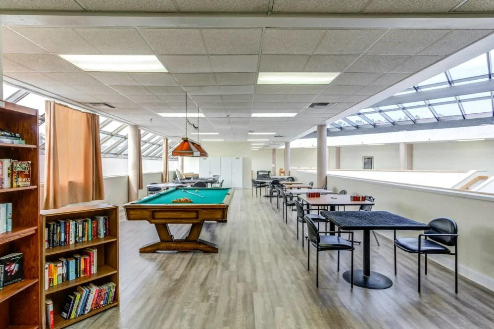 a game room with pool tables and bookshelves