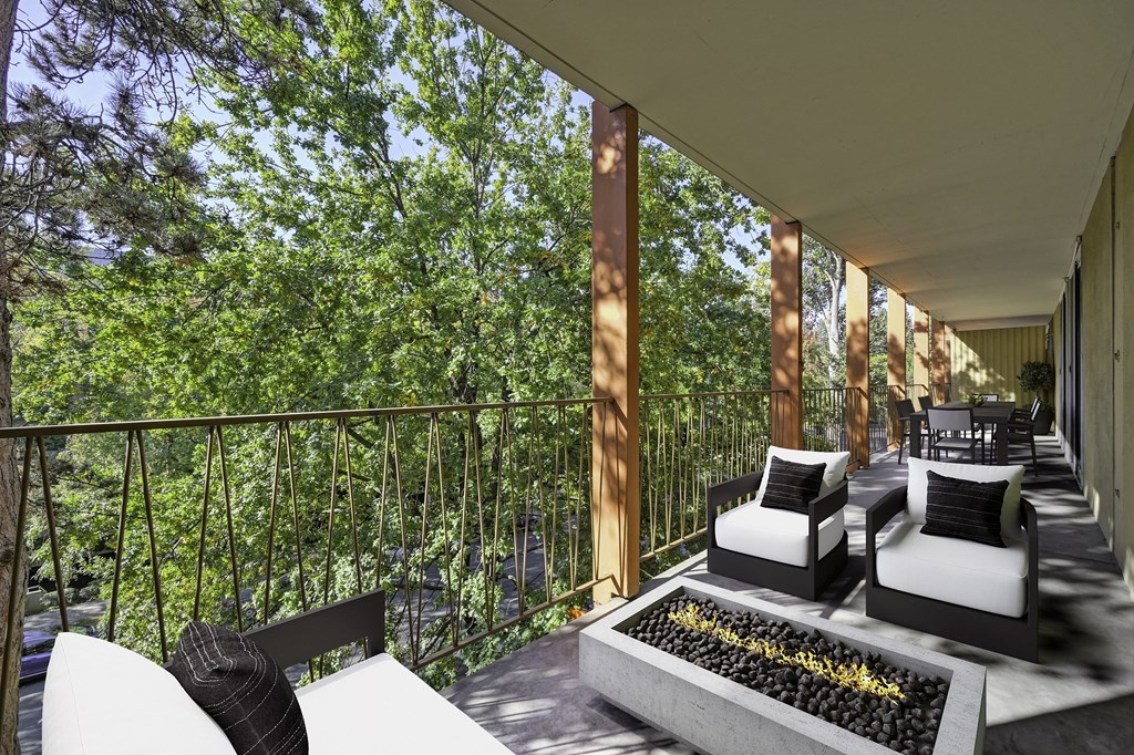 a balcony with couches and chairs and a fire pit at The Riverview (55+), Sacramento California