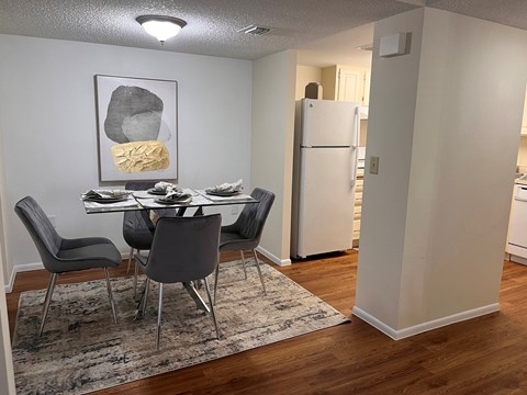 A dining room with a table and chairs.