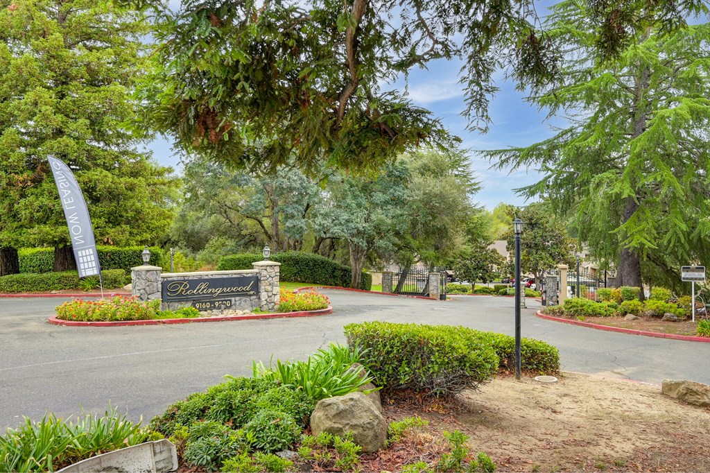 a street with a sign at the entrance of a park