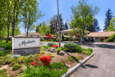 A sign that says "Madison" is in front of a building.