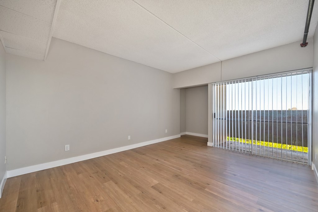 Empty room with wooden floor and white walls.