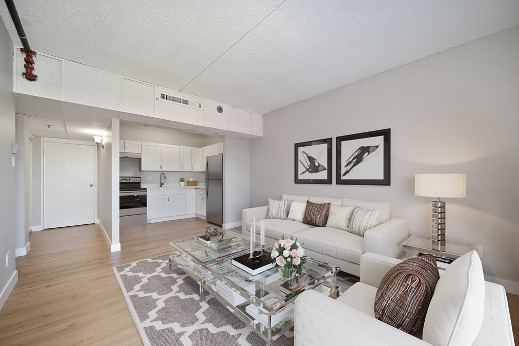 A living room with a white couch and a glass coffee table.