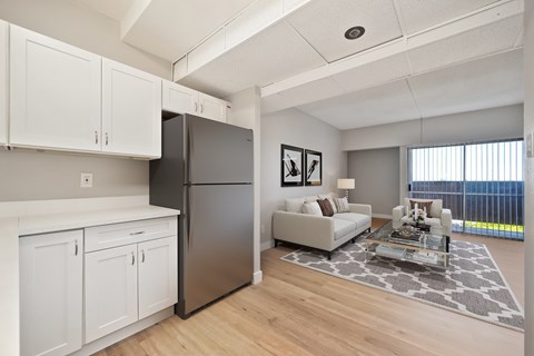 A modern kitchen with white cabinets and a black refrigerator.