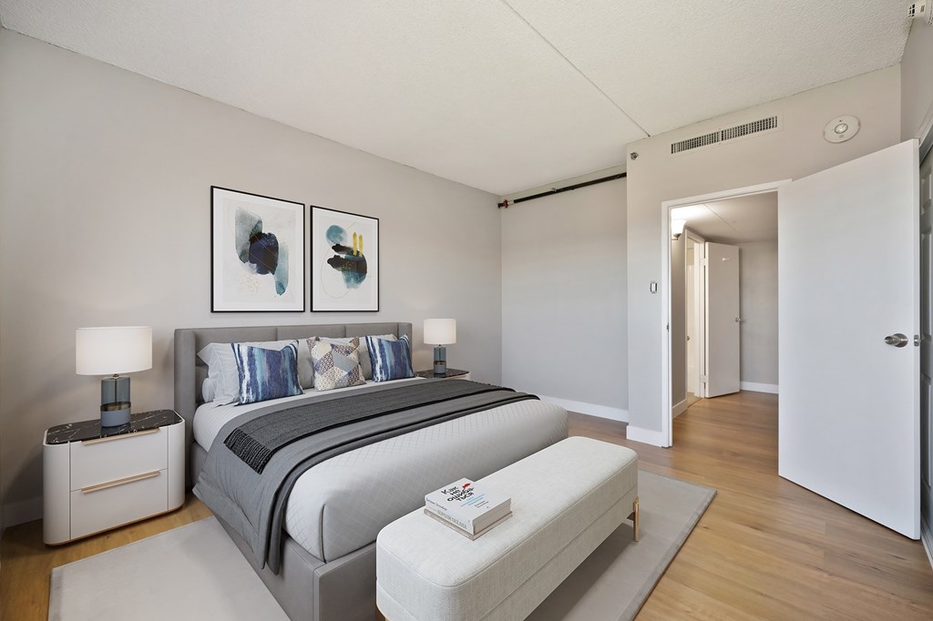 A bedroom with a large bed and two nightstands.