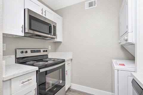 A kitchen with white cabinets and appliances.