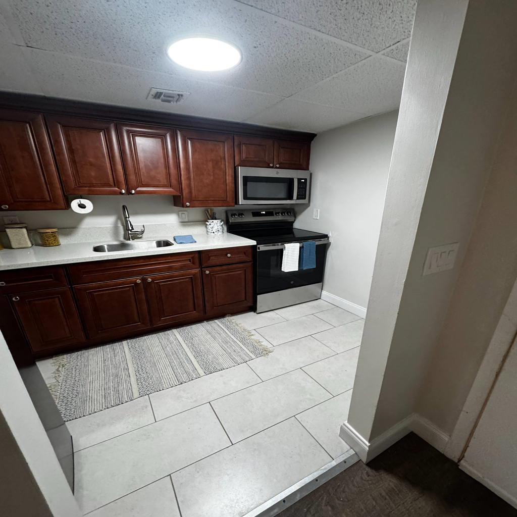 A kitchen with brown cabinets and a white counter top.
