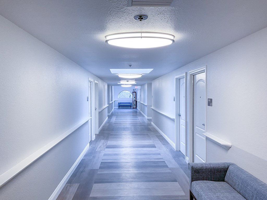 a hallway with white walls and a wooden floor