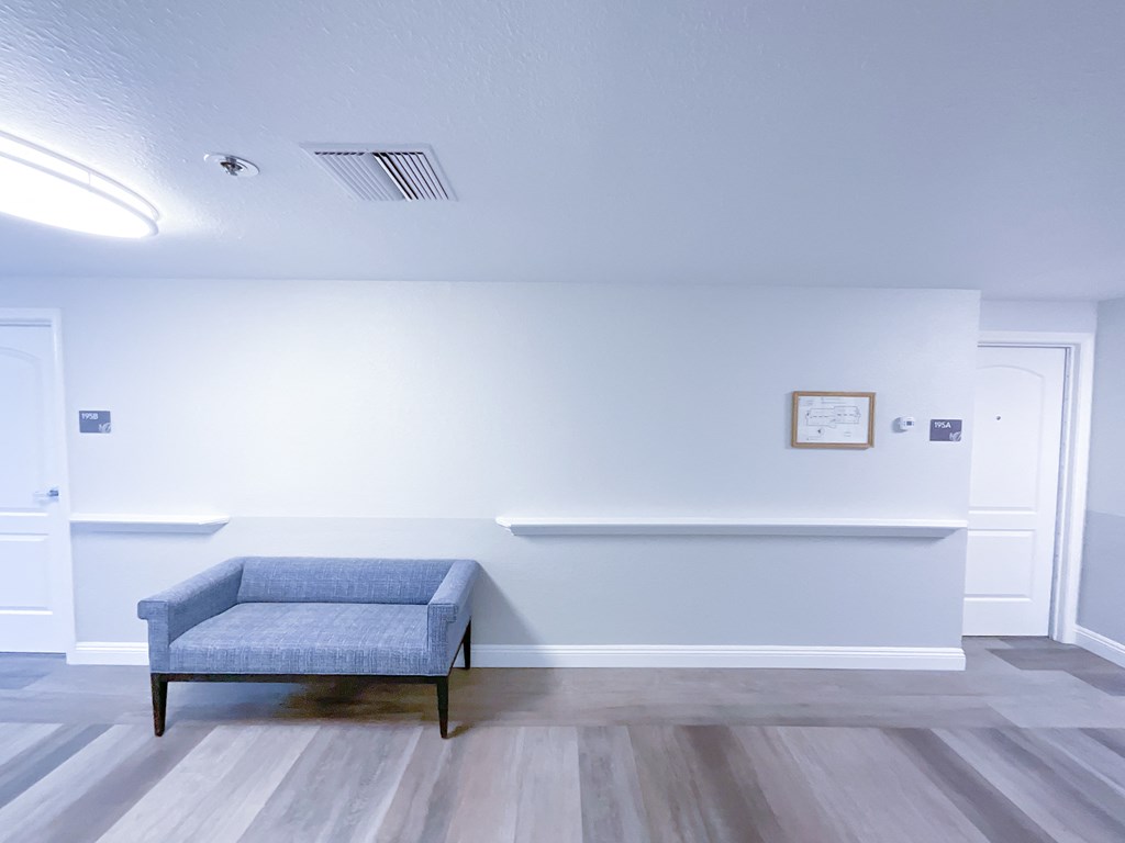a room with a blue chair and white walls