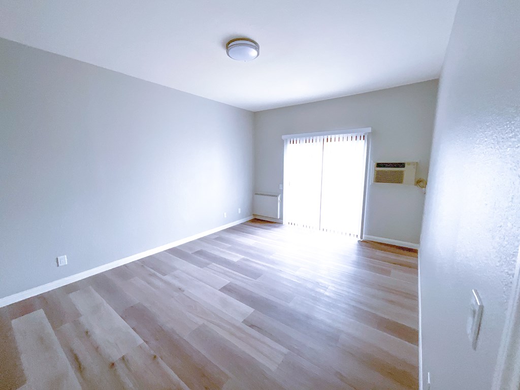 a bedroom with hardwood floors and grey walls
