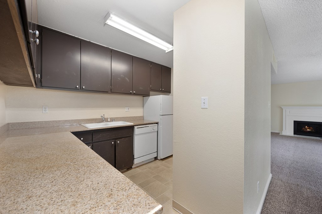 a kitchen with white appliances and dark cabinets