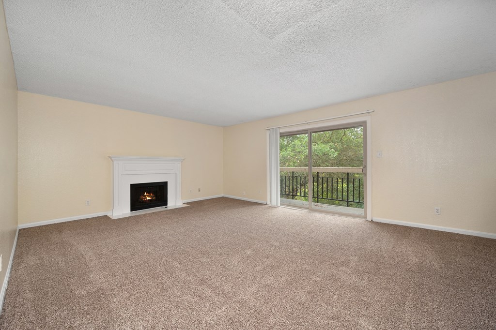 an empty living room with a fireplace and a window