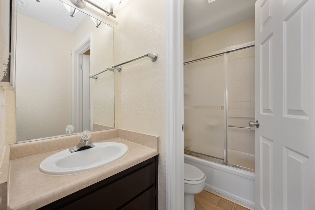 a bathroom with a sink and a shower and a toilet