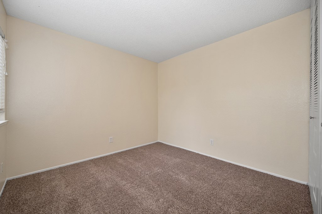 an empty room with beige carpet and white walls