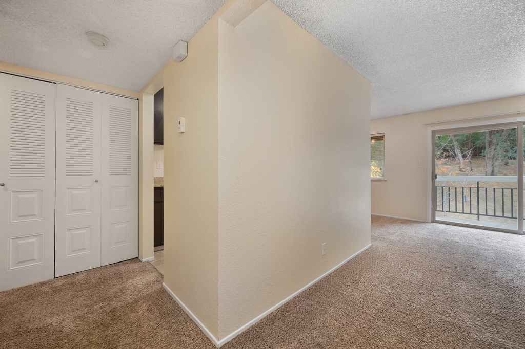 an empty living room with a door to a balcony