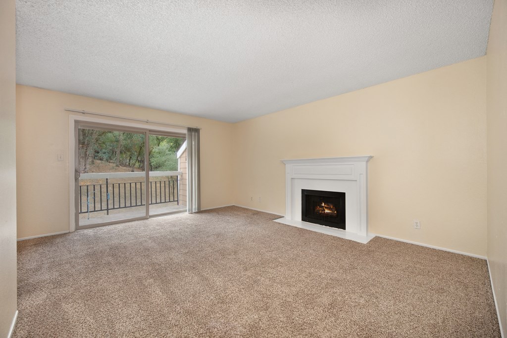 an empty living room with a fireplace and a window