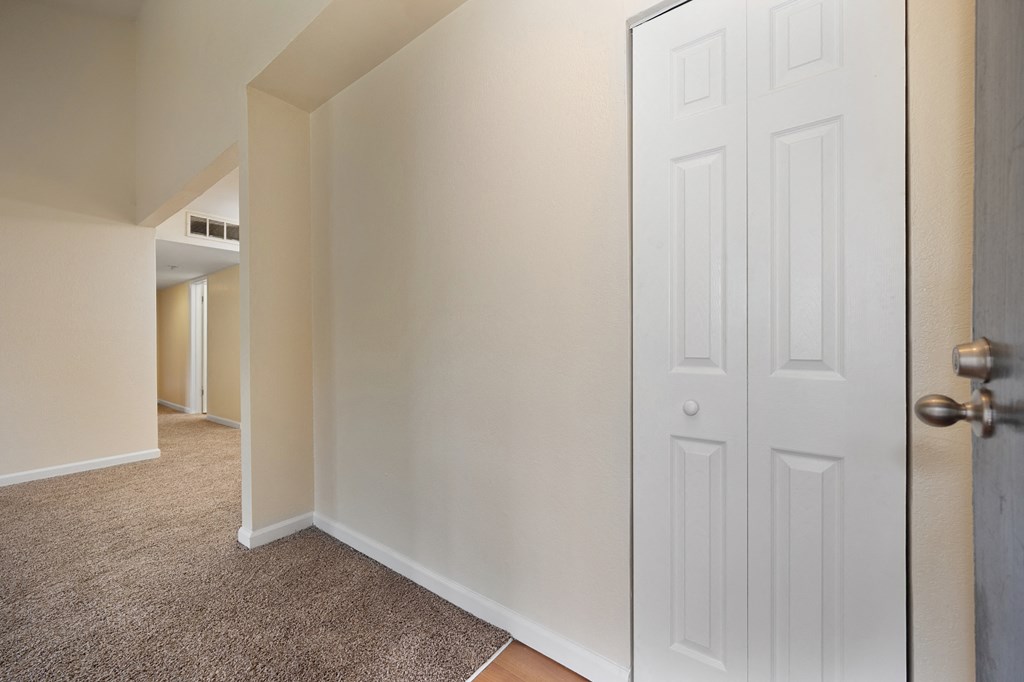 an empty room with a white door and a carpeted floor