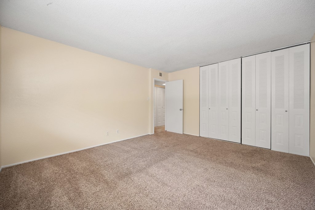 an empty living room with white closet doors