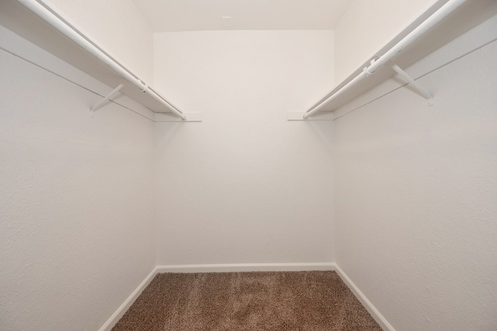 an empty room with white walls and a brown carpet