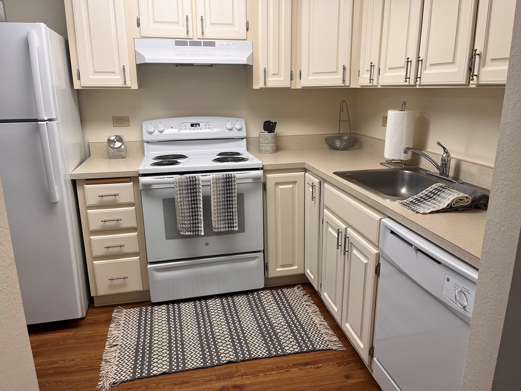 A kitchen with a white oven and white cabinets.