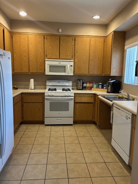 A kitchen with wooden cabinets and white appliances.