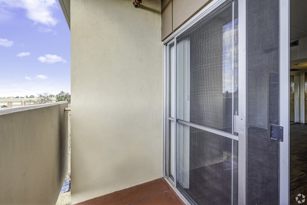 a balcony with a sliding glass door and a patio