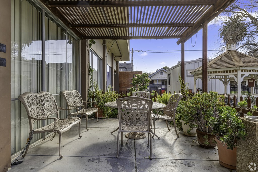 a covered patio with chairs and tables and a gazebo