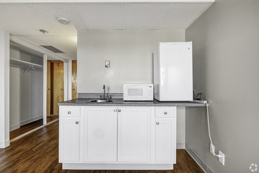 an empty kitchen with a microwave and a refrigerator