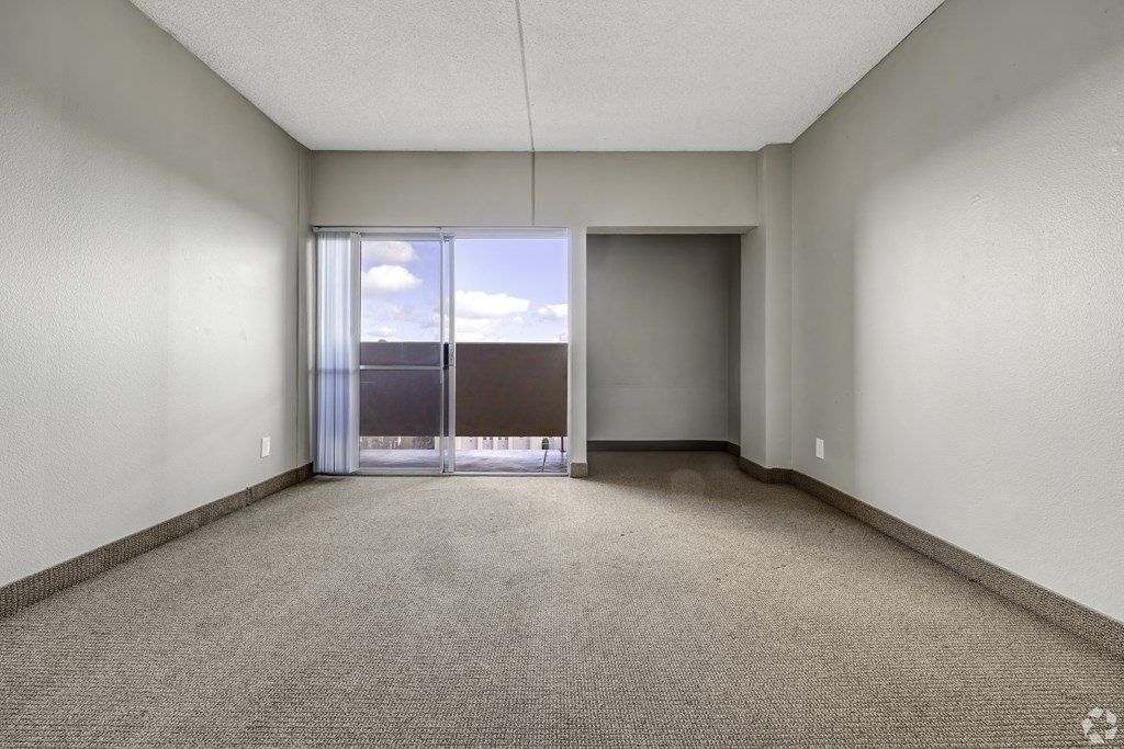 an empty room with a balcony and sliding glass doors