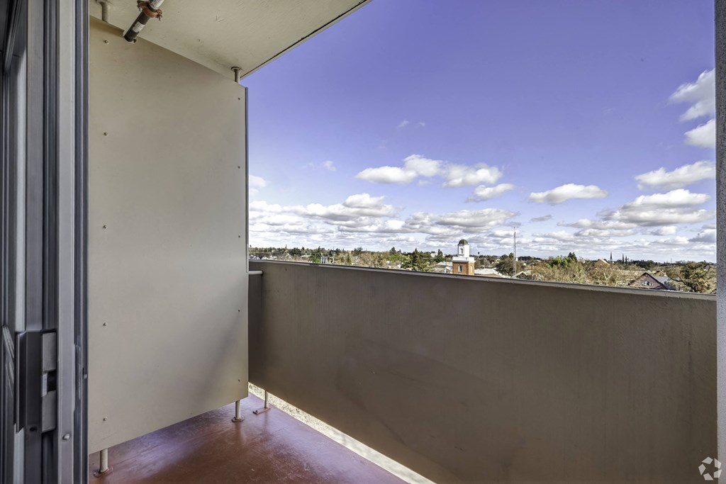a balcony with a view of the city and a blue sky