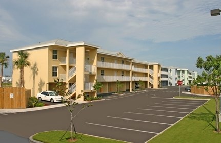 A car is parked in a parking lot in front of a building.