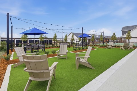 A sunny day at the park with blue umbrellas and wooden chairs.