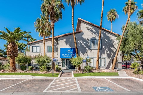 Property entrance with landscaping and palm trees at Playa Vista Apartments, Las Vegas, Nevada