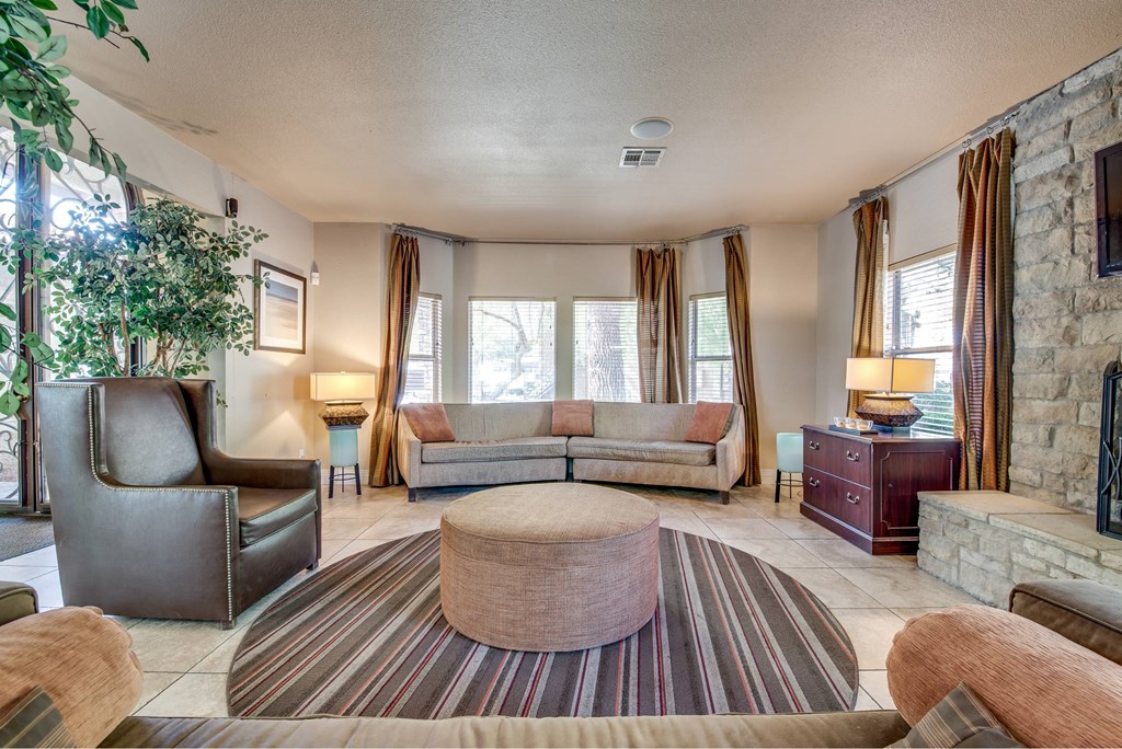 A living room with a couch, chair, and fireplace.
