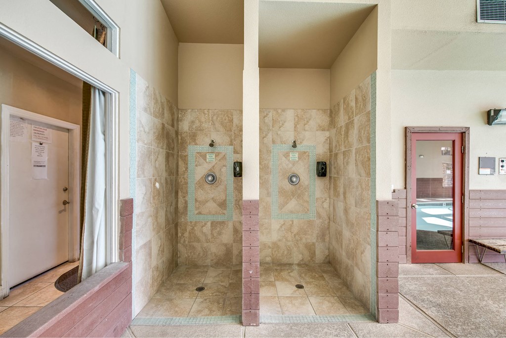 A bathroom with a shower and a red door.