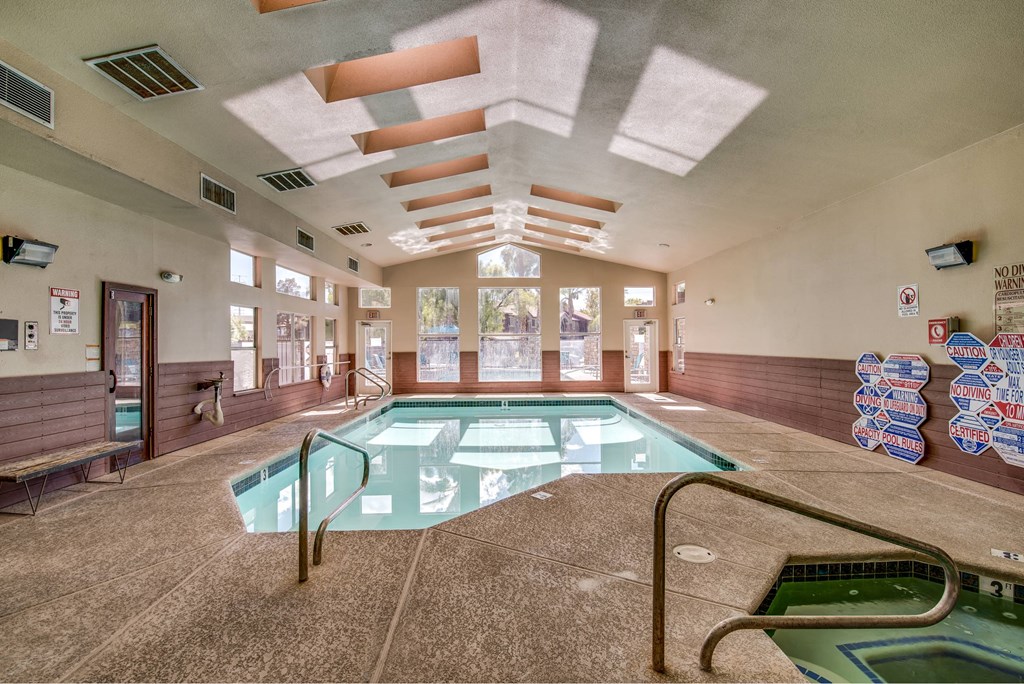 A large indoor swimming pool with a glass divider and a metal ladder.