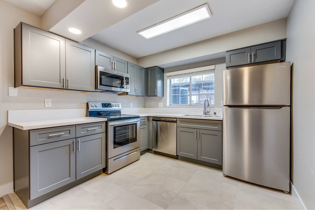 A kitchen with stainless steel appliances and a skylight.