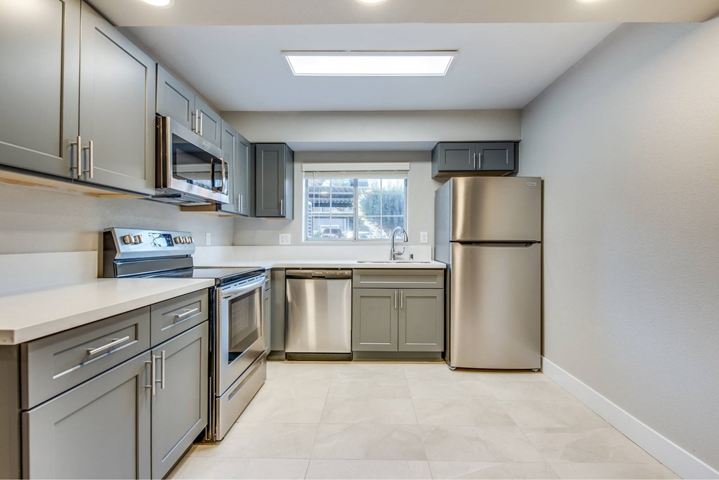 A kitchen with stainless steel appliances and a window.