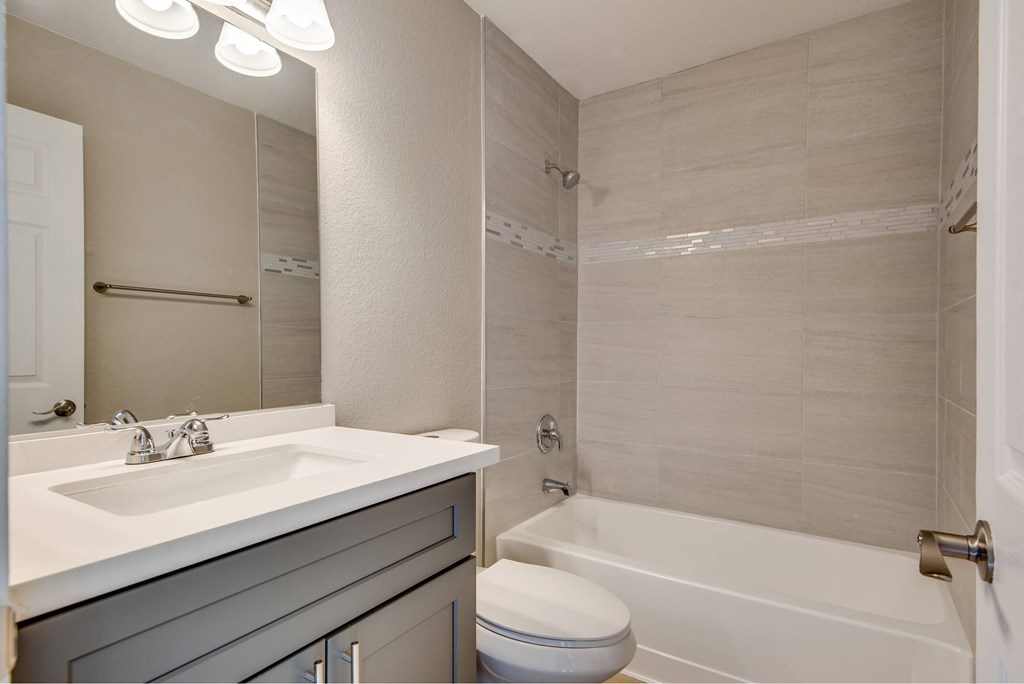 A modern bathroom with a white sink and a white bathtub.