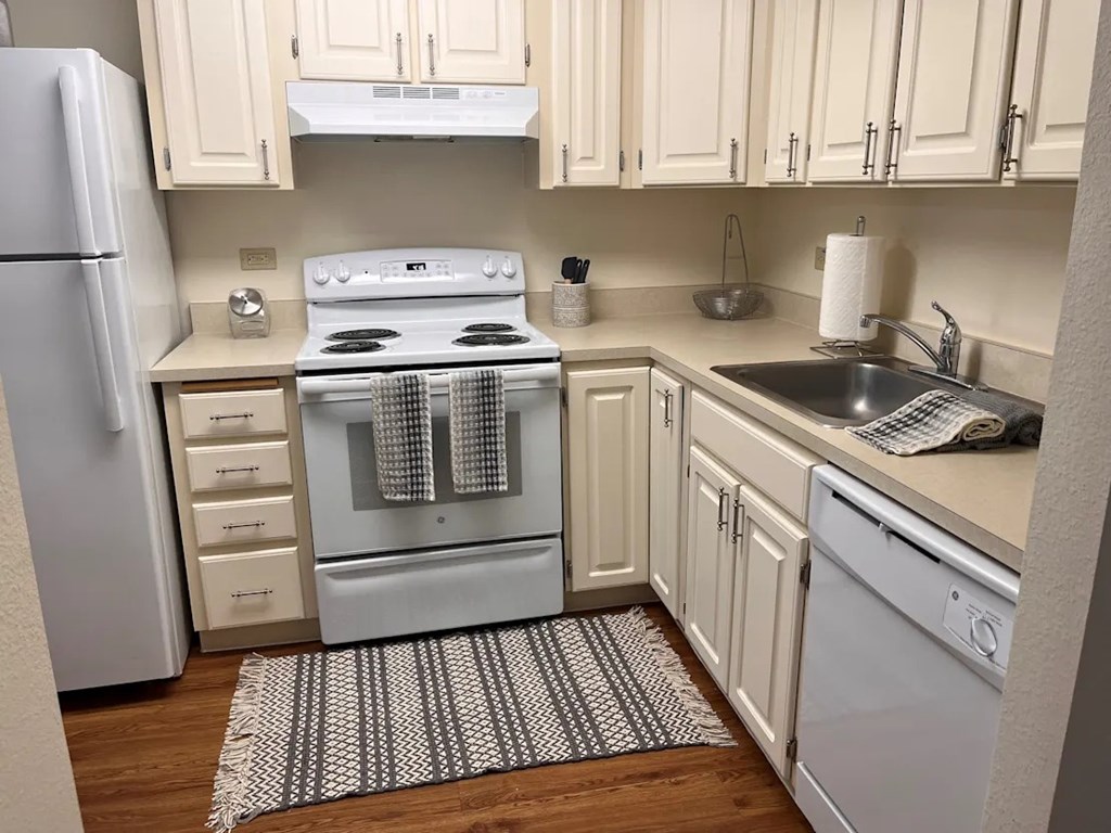 A kitchen with a white oven and white cabinets.