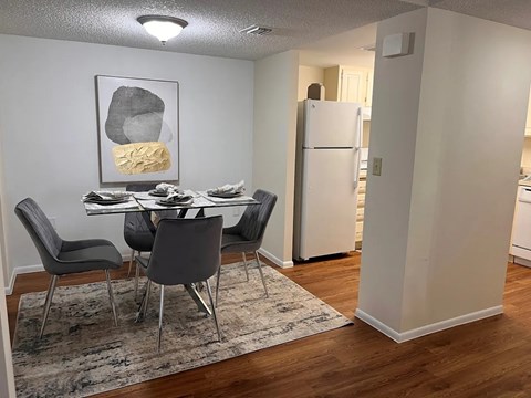 A dining room with a table and chairs.