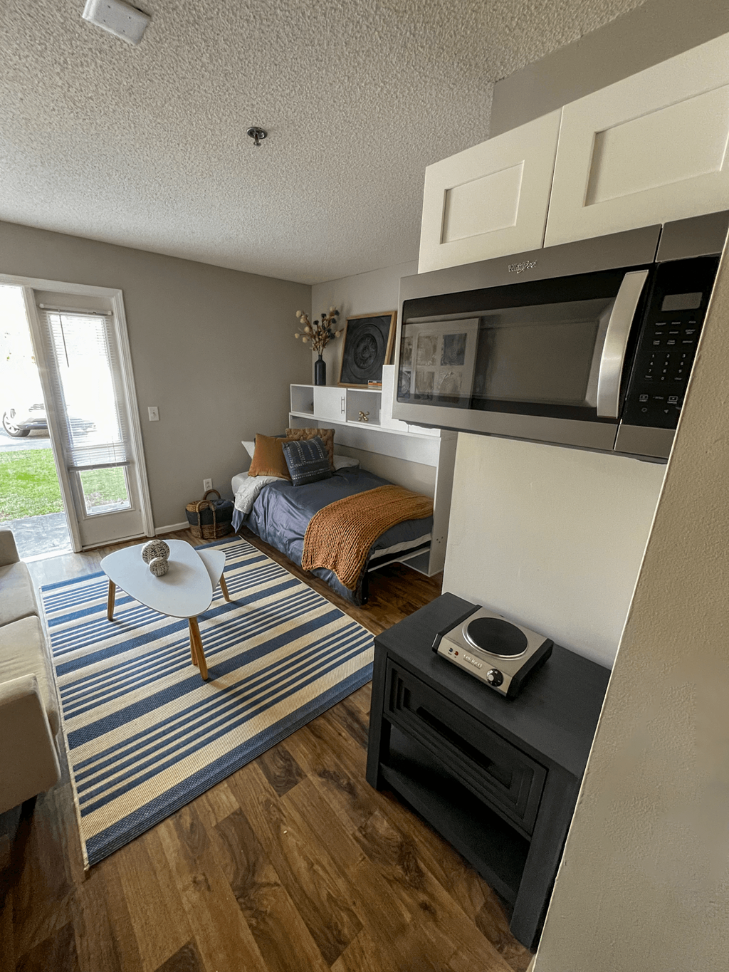 an overhead view of a studio apartment with a bed and a microwave