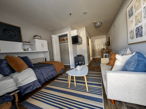 a living room with a couch and a chair and a tv