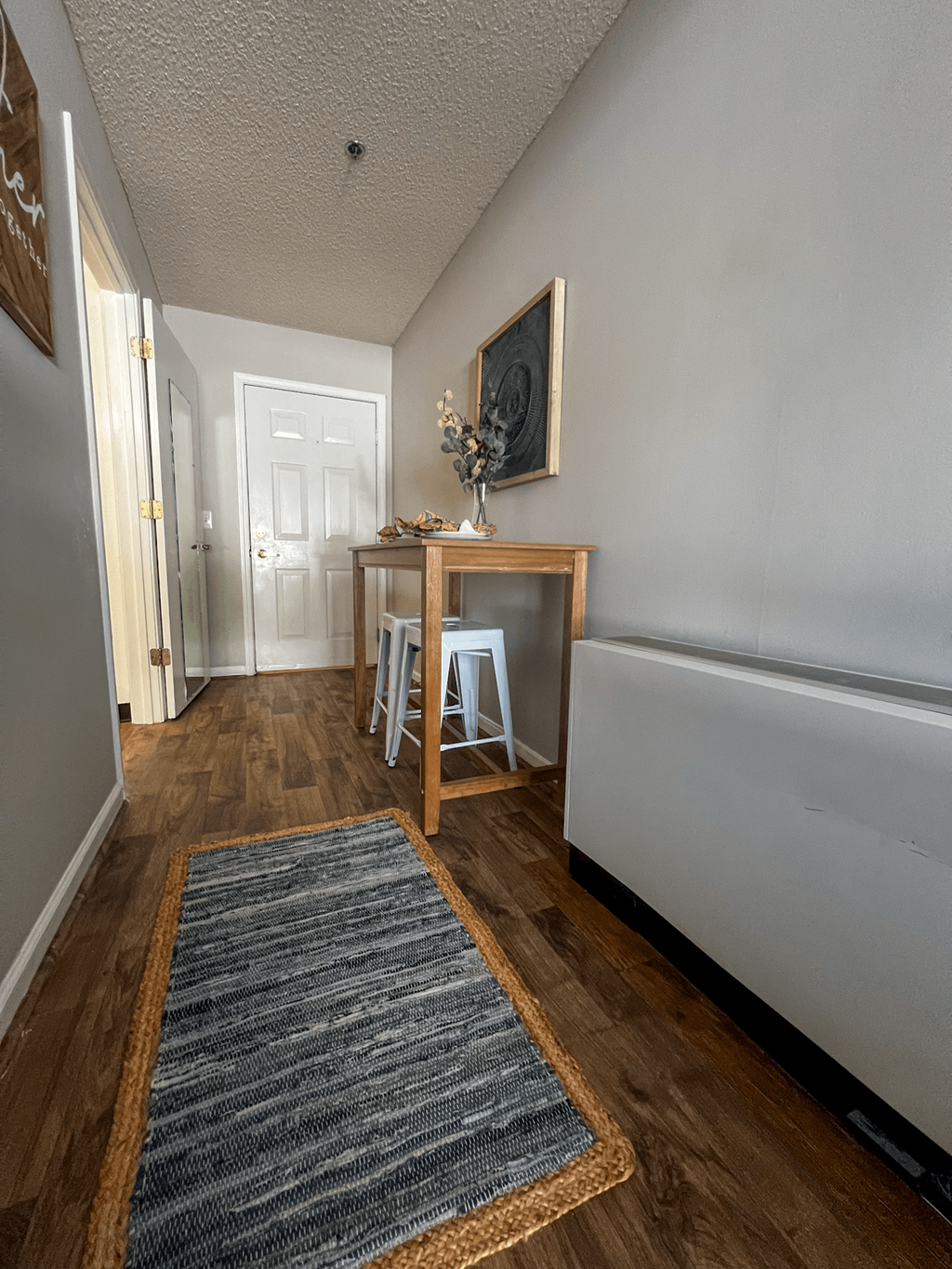 a living room with a table and a hallway with a door